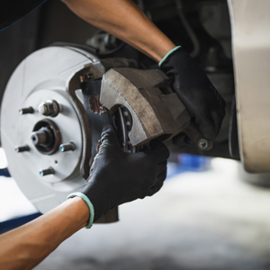 maintenance and repair of vehicle wheel being undertaken by mechanic hands